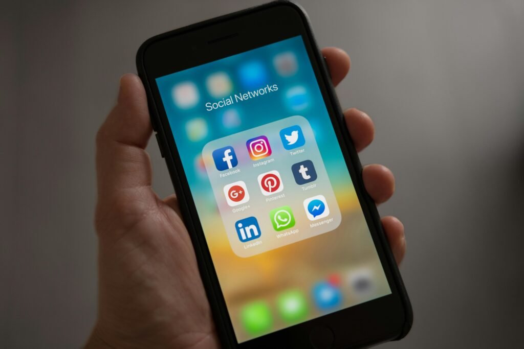 A smartphone displaying various social media icons for the discussion of social media management price